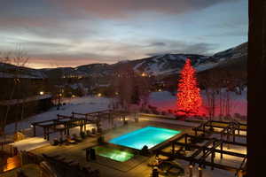 Snow covered pool with a mountain view