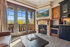 Carpeted living room with a stone fireplace