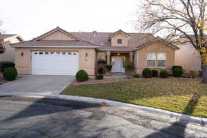 View of front of house featuring a garage and a front yard