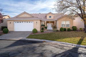 View of front facade featuring a front yard and a garage