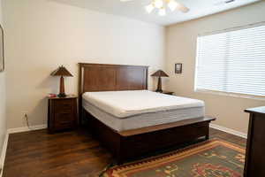 Bedroom with ceiling fan and dark wood-type flooring