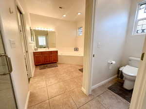 Full bathroom with toilet, vanity, tile patterned floors, and plus walk in shower