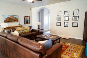 Living room with dark hardwood / wood-style floors and ceiling fan