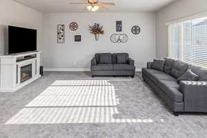 Carpeted living room featuring ceiling fan