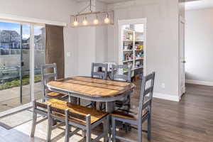 Dining space with dark wood-type flooring