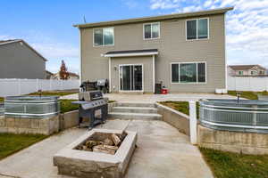 Rear view of property featuring a patio area and an outdoor fire pit