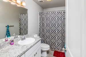 Bathroom featuring tile patterned floors, vanity, and toilet