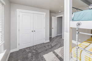 Carpeted bedroom with a closet