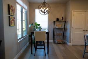 Dining room featuring hardwood / wood-style flooring, an inviting chandelier, and a healthy amount of sunlight