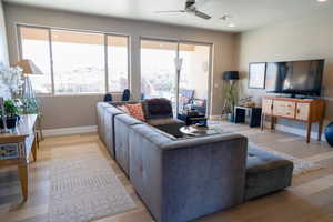 Living room with ceiling fan and light wood-type flooring