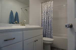 Full bathroom with vanity, toilet, and shower / bathtub combination with curtain