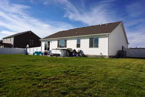 Rear view of property with a yard and a patio