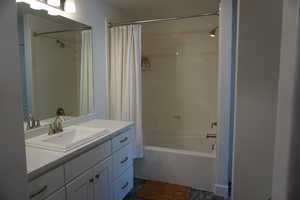 Bathroom featuring vanity and shower / bath combination with curtain