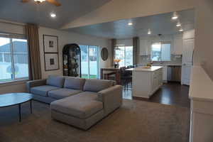 Living room featuring dark hardwood / wood-style floors, ceiling fan, lofted ceiling, and sink