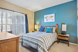 Bedroom with multiple windows and light colored carpet