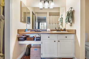 Bathroom with hardwood / wood-style flooring, vanity, and toilet