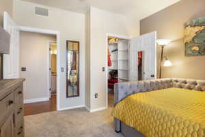 Bedroom featuring light carpet, a walk in closet, and a closet