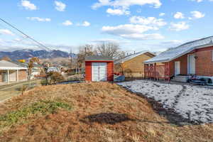 View of yard featuring a mountain view and a storage shed