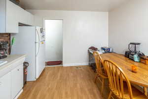 Kitchen featuring white fridge, white cabinetry, and light hardwood / wood-style flooring