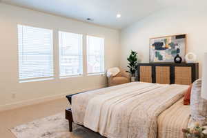 Carpeted bedroom featuring vaulted ceiling