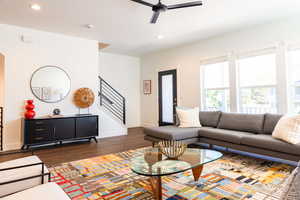 Living room with ceiling fan and dark hardwood / wood-style floors