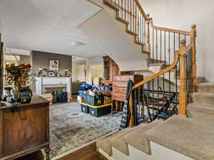 Stairway featuring hardwood / wood-style floors and a tiled fireplace