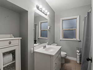 Bathroom featuring tile patterned flooring, vanity, and toilet