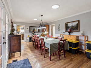 Dining area featuring crown molding and light hardwood / wood-style flooring