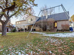 Rear view of house with a patio area and a yard