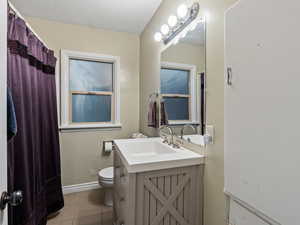 Bathroom with tile patterned floors, vanity, and toilet