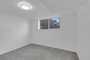 Carpeted spare room with a textured ceiling