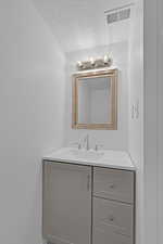 Bathroom featuring vanity and a textured ceiling