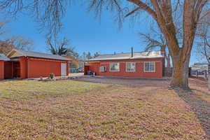 Back of property with a lawn, cooling unit, and an outbuilding