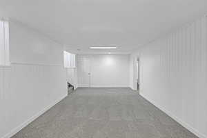 Basement featuring carpet, a textured ceiling, and wood walls