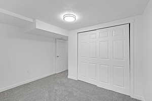 Unfurnished bedroom featuring carpet, a textured ceiling, and a closet