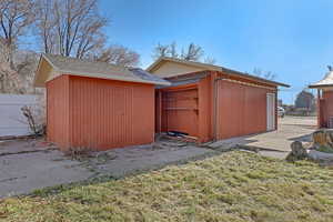 View of outbuilding featuring a lawn