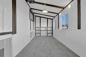 Interior space with vaulted ceiling with beams and wooden walls