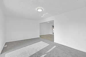 Carpeted empty room featuring a textured ceiling