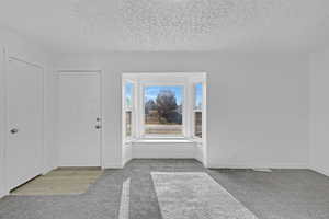 Entryway featuring light carpet and a textured ceiling