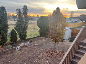 Yard at dusk featuring a storage unit