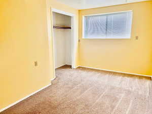 Unfurnished bedroom featuring carpet flooring and a closet