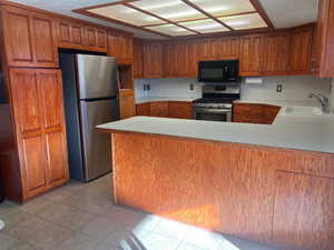 Kitchen with sink, kitchen peninsula, and stainless steel appliances