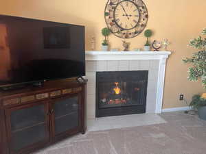 Interior details with carpet and a tile fireplace