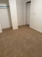 Unfurnished bedroom with a closet, baseboards, and carpet flooring