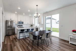 Dining space featuring medium hardwood / wood-style flooring and an inviting dining chandelier