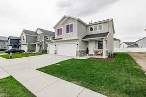 View of front of property featuring a 3 car garage and a front yard