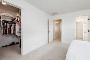 Main Bedroom with light carpet and a closet