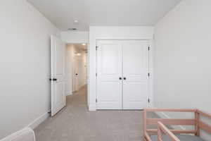 Bedroom featuring a closet and light colored carpet