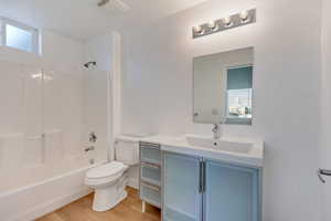 Full bathroom with bathtub / shower combination, wood-type flooring, vanity, and toilet