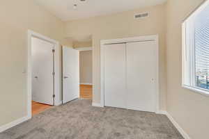 Unfurnished bedroom featuring light colored carpet and a closet